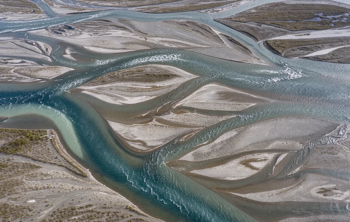 Interweaving blue river courses surrounding elongated gravel islands